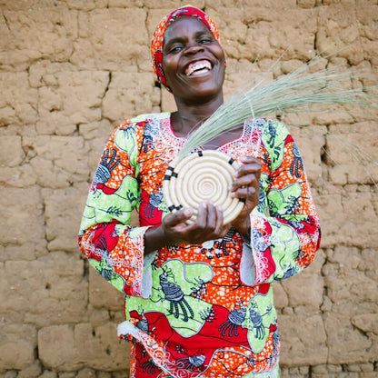 Rwandan Artisan showing off her handwoven wall plate
